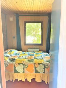 1 dormitorio con cama con edredón y ventana en Nice Holiday Home Near Tisvilde Town And Beach, en Vejby