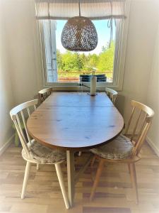 una mesa de madera con sillas en una habitación con ventana en Nice Holiday Home Near Tisvilde Town And Beach, en Vejby