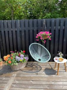 un patio con una silla, flores y una mesa en Nice Holiday Home Near Tisvilde Town And Beach, en Vejby