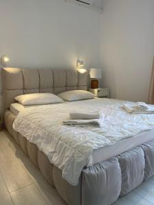 a large white bed in a bedroom with two pillows at Sun&Moon Apartment Obzor in Obzor