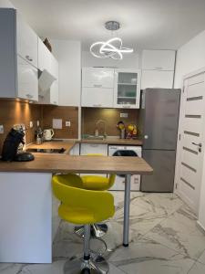 a kitchen with a table and two yellow chairs at Sun&Moon Apartment Obzor in Obzor