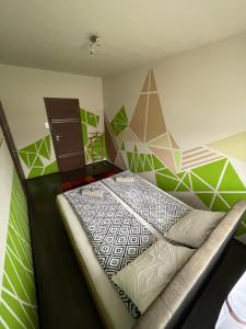 um quarto com uma cama com paredes verdes e brancas em Exkluzív Apartman Debrecen em Debrecen