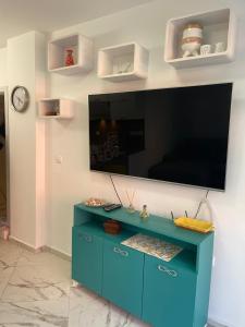 a blue cabinet with a flat screen tv on a wall at Sun&Moon Apartment Obzor in Obzor