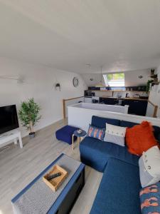 uma sala de estar com um sofá azul e uma mesa em Holly Lodge em Pembrokeshire