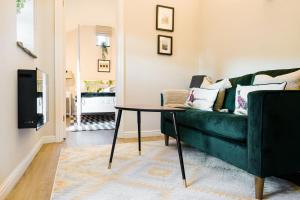 a living room with a green couch and a table at The Pigsty in Buxton