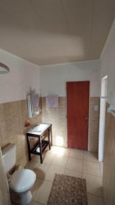 a bathroom with a toilet and a table and a red door at AbbeyHouse descanso y vacaciones in Victoria