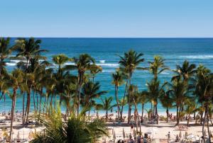 a view of a beach with palm trees and the ocean at Riu Palace Bavaro - All Inclusive in Punta Cana