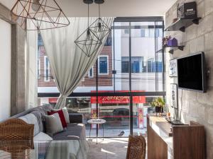 a living room with a couch and a large window at Residencial Aroeira in Balneário Camboriú