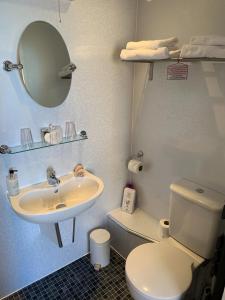 a bathroom with a sink and a toilet and a mirror at The Middleham in Whitby