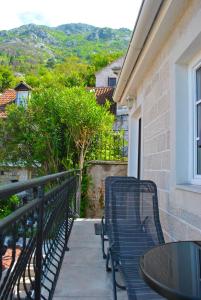 a blue bench sitting on a balcony with a table at Apartment Mediterraneo Blue Sky in Perast