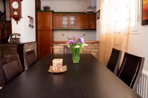 a dining room table with a vase of flowers on it at Serenità in Lefkimmi
