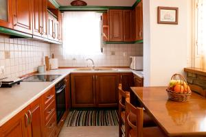 a kitchen with wooden cabinets and a table with a basket of fruit at Serenità in Lefkimmi
