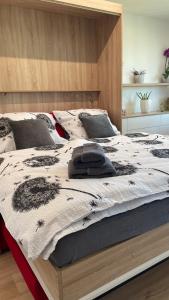 a large bed with a black and white blanket on it at Apartmán na Zahradní in Kyjov
