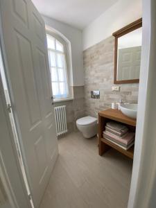 a bathroom with a toilet and a sink and a mirror at Bellaisa Bed & Breakfast in Camaiore