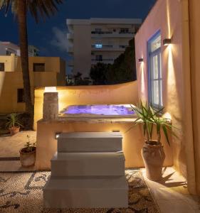 a patio with a bed and a window at night at Casa del Sol Suites in Rhodes Town
