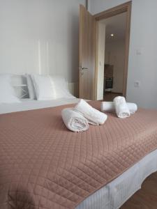 a bed with two pillows and towels on it at Sun Meets Sea in Athanion