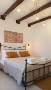 a bedroom with a bed with white sheets and orange pillows at Antiche Mura Apartments"Cielo di Puglia" -2 matrimoniali, cucina,letto singolo e terrazzo in Turi