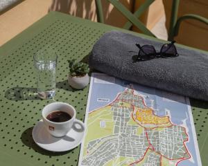 een tafel met een kopje koffie en een kaart bij Casa del Sol Suites in Rhodos-stad