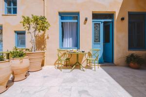 a patio with chairs and a table in front of a house at Casa del Sol Suites in Rhodes Town