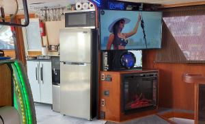 a kitchen with a tv and a stove with a fire at Romantic Condo @ Ocean 3-deck Yacht in Brooklyn