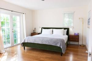 a bedroom with a large bed and a large window at Coconut Grove Hidden Sanctuary Townhouse in Miami