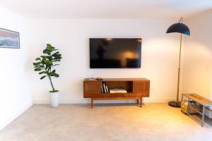 uma sala de estar com uma televisão e um vaso de plantas em Coconut Grove Hidden Sanctuary Townhouse em Miami