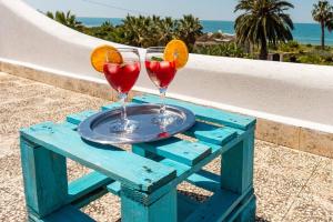 dois cocktails numa mesa azul com um prato em Villa Luisa Il Giardino sul mare em Sciacca