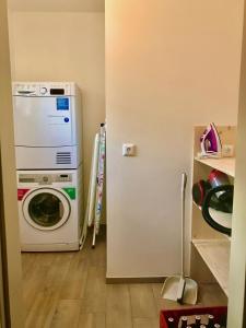 a kitchen with a washing machine and a refrigerator at 4Luxuriöses Ferienhaus in traumhafter Landschaft in Döbriach