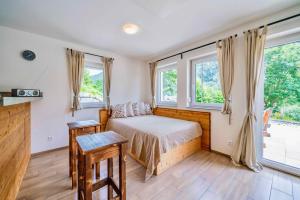 een slaapkamer met een bed en 2 ramen bij 4Luxuriöses Ferienhaus in traumhafter Landschaft in Döbriach