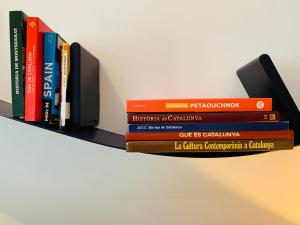 a stack of books sitting on a shelf at Hermoso piso en el centro de Barcelona in Barcelona