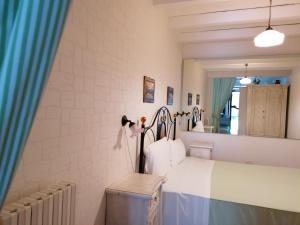 a bedroom with a white bed and a mirror at Bed & Breakfast da Fabio e Paola in Ostuni