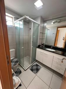 a bathroom with a glass shower and a toilet at West Flat in Mossoró