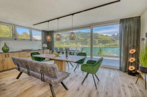 a dining room with a table and chairs and a large window at Chalet Lake View - by Alpen Apartments in Zell am See
