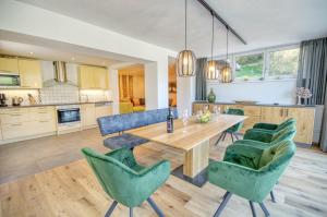 a kitchen and living room with a wooden table and chairs at Chalet Lake View - by Alpen Apartments in Zell am See