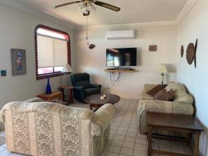a living room with two couches and a tv at Beachfront, 2 bedroom Condo in San Felipe in San Felipe