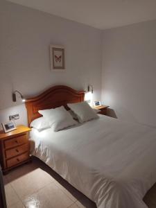 1 dormitorio con 1 cama blanca grande y 2 mesitas de noche en CAL JAN - SOLANA en Bellver de Cerdanya 