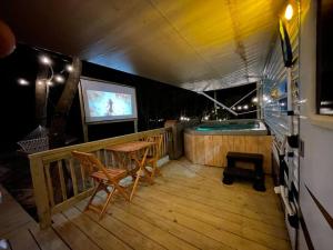 een balkon met een zwembad en een tafel en stoelen bij Ramblin Rose Camper - Theater - Hot-Tub - Fire Pit 