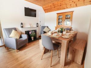 uma sala de jantar com uma mesa de madeira e cadeiras em Sweeney's Cottage em Beaufort