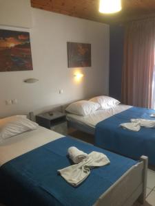 Dos camas en una habitación de hotel con toallas. en Fotini's Beach, en Olympiakí Aktí