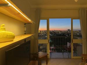 a room with a balcony with a view of a city at RelaxRP in Ribeirão Preto