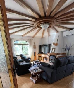 ein Wohnzimmer mit einem Sofa und einem Deckenventilator in der Unterkunft Villa GAN EDEN in La Drova
