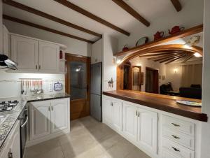 a kitchen with white cabinets and a counter top at Villa GAN EDEN in La Drova