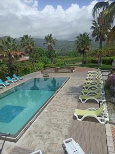 - une grande piscine avec des chaises longues et un bouquet dans l'établissement Tenuta del Bifan, à Policastro Bussentino