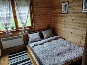 Habitación con cama en una cabaña de madera en Nexus B2 en Făgeţel