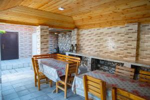 a dining room with a table and chairs on a patio at Gostevoy Dom Гостевой Дом in Sheki