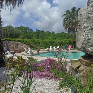 - une piscine entourée de chaises et de fleurs dans la cour dans l'établissement Tenuta del Bifan, à Policastro Bussentino