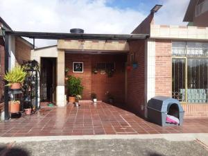 uma casa de tijolos com um pátio de tijolos com um forno exterior em Preciosa casa de descanso a 10 min de Villa de Leyva em Sutamarchán