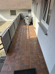 a balcony with a tiled floor next to a building at FEWO LION in Ettenheim