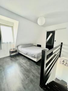 a white room with a bed and a window at Un été sans fin à Deauville in Deauville