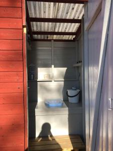 ein Schatten einer Person in einem Bad mit WC in der Unterkunft Stuga med sjöläge in Kopparberg